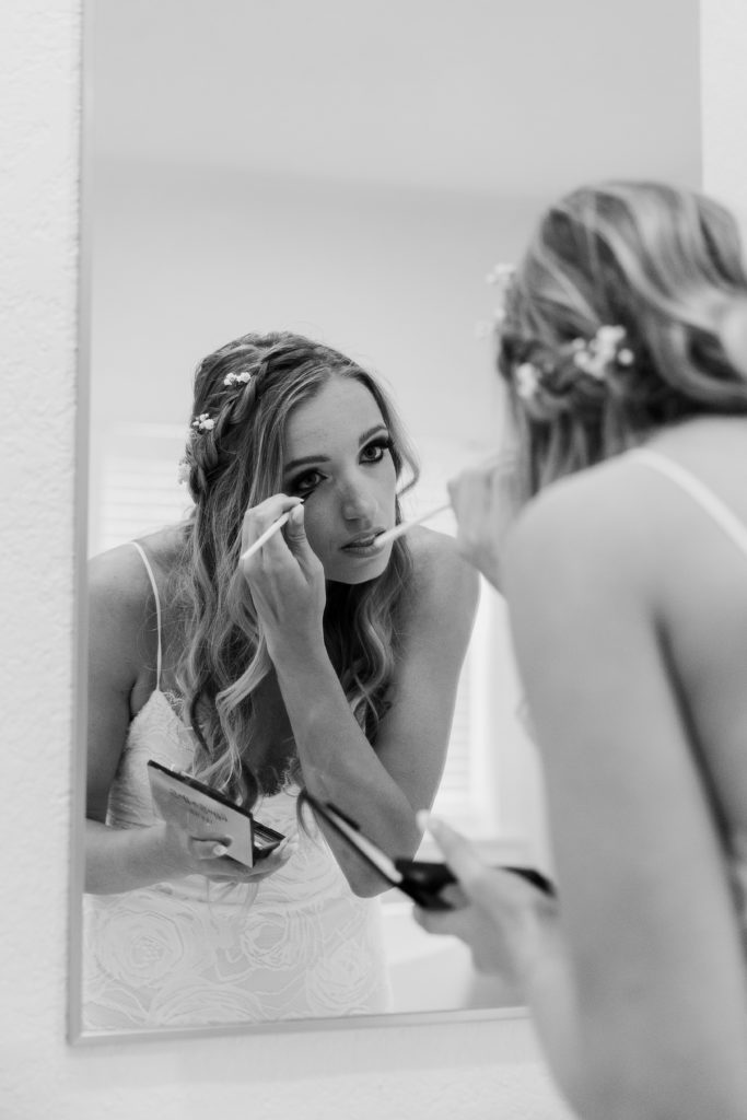 Woman touching up her makeup before heading out to her beach ceremony in Florida