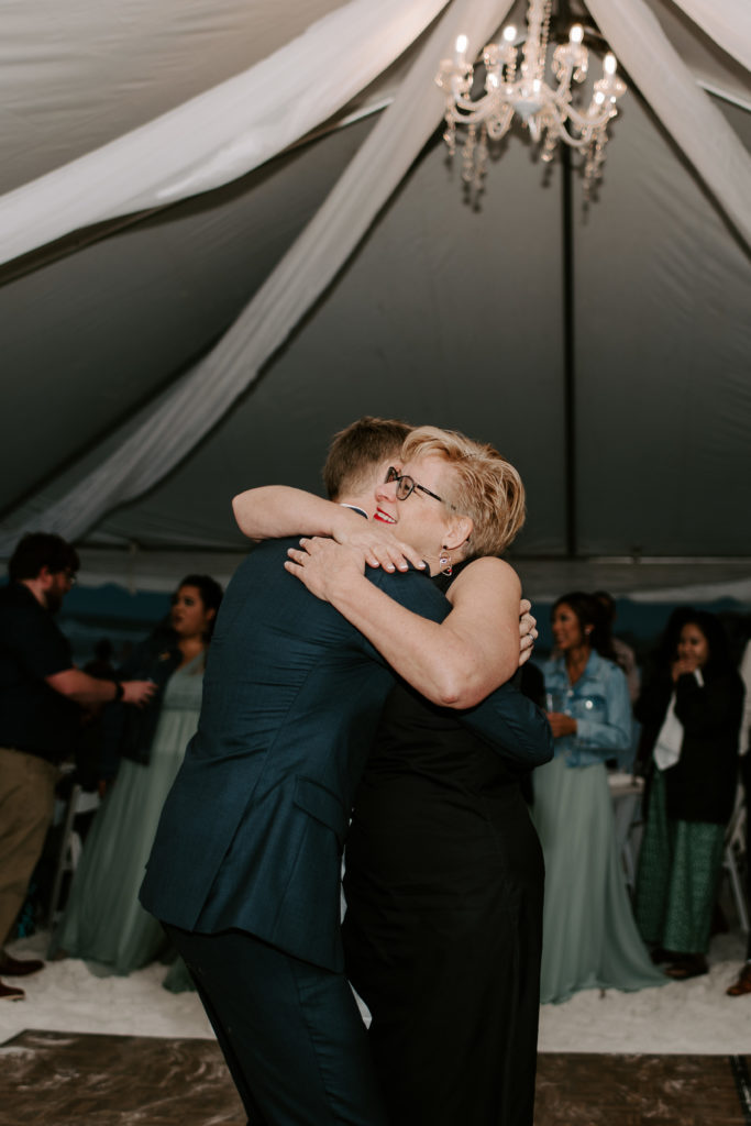 Mother of the groom giving her son a big hug at the end of their dance