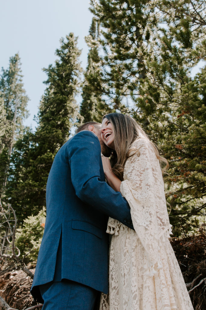 Man whispering into his new wives ear as she laughs during their PNW elopement