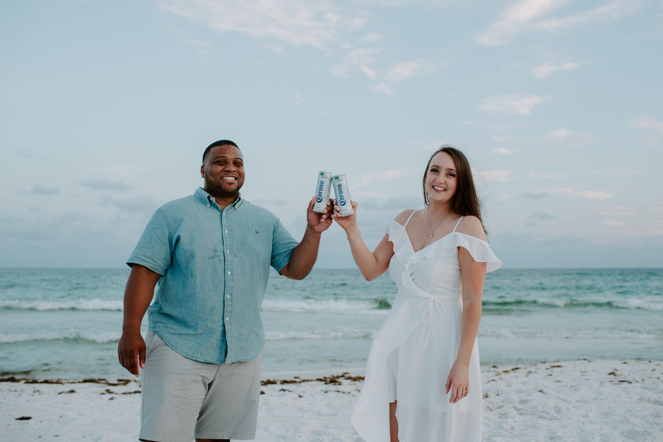 Couple cheering their corona beers during their one year anniversary session at Henderson Beach State park