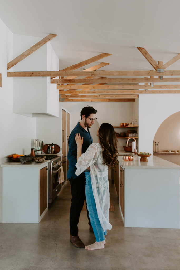 A couple dancing in their kitchen as the sun streams through their backdoor during their Palm Springs engagement photos