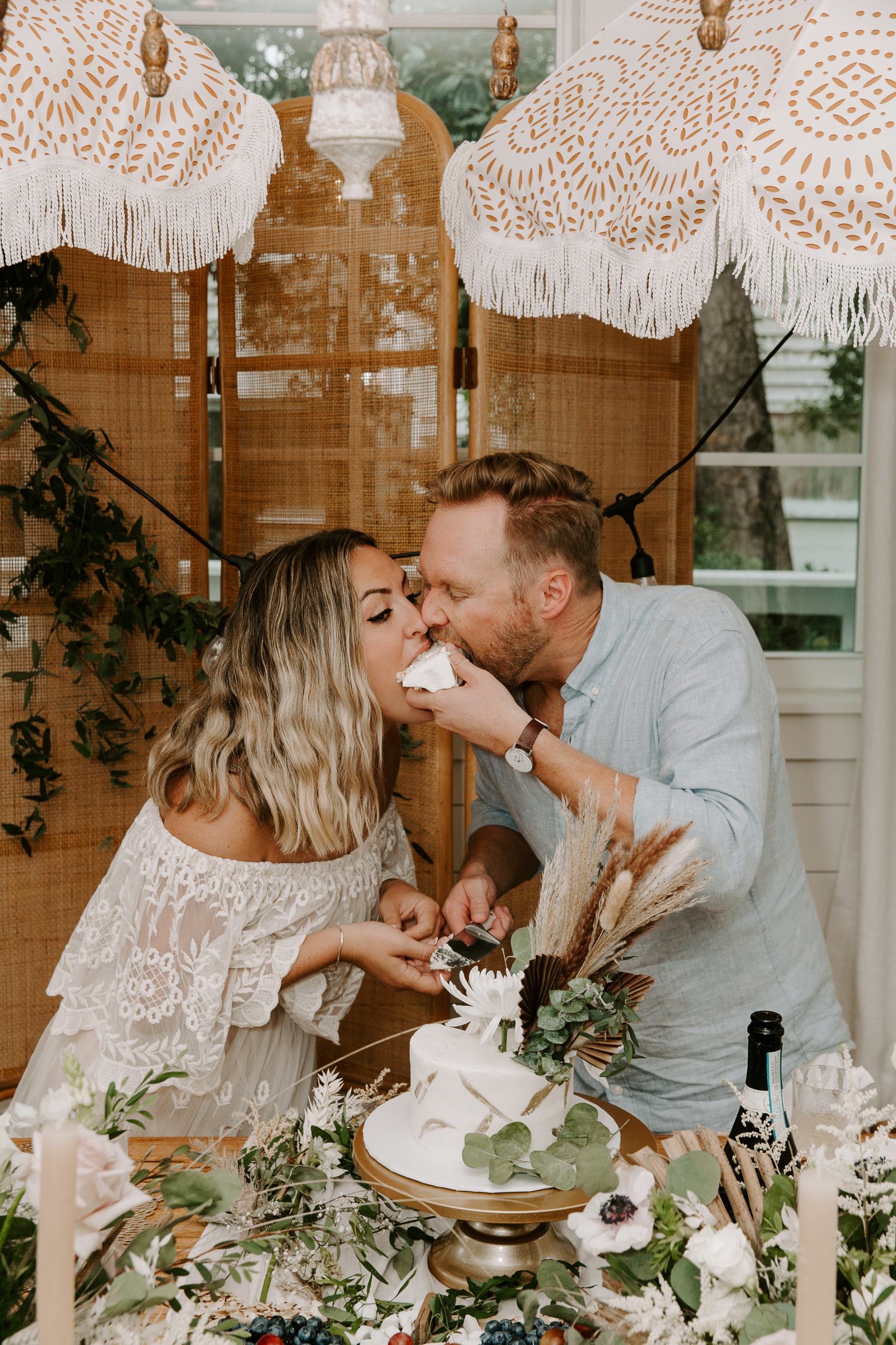 Couple eating cake at the same time after cutting it during their 30A wedding