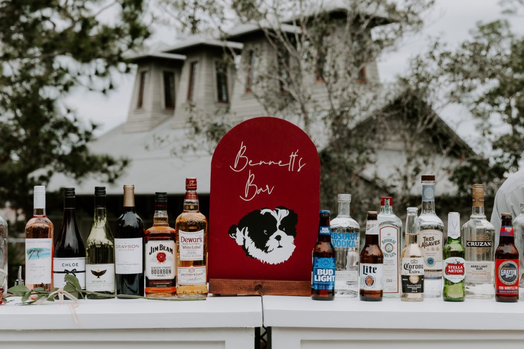 Bar signs with the couples dog on it during their 30A wedding reception