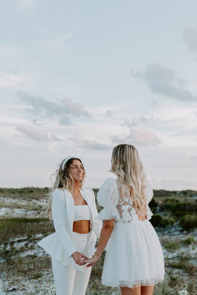 A woman holding her partner's hands as they say their vows to each other at their beach ceremony during their Florida elopement