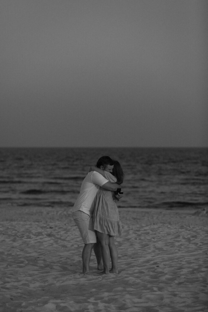 Woman hugging her partner tightly after he proposed on the beach in dolphin Island Alabama
