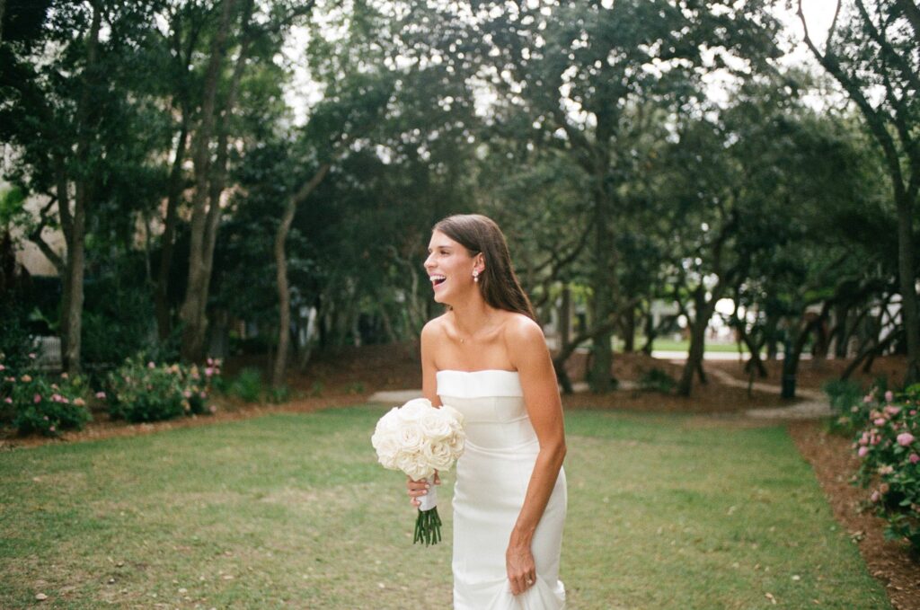 a bride laughing as she is holding her wedding bouquet during her 30-a wedding