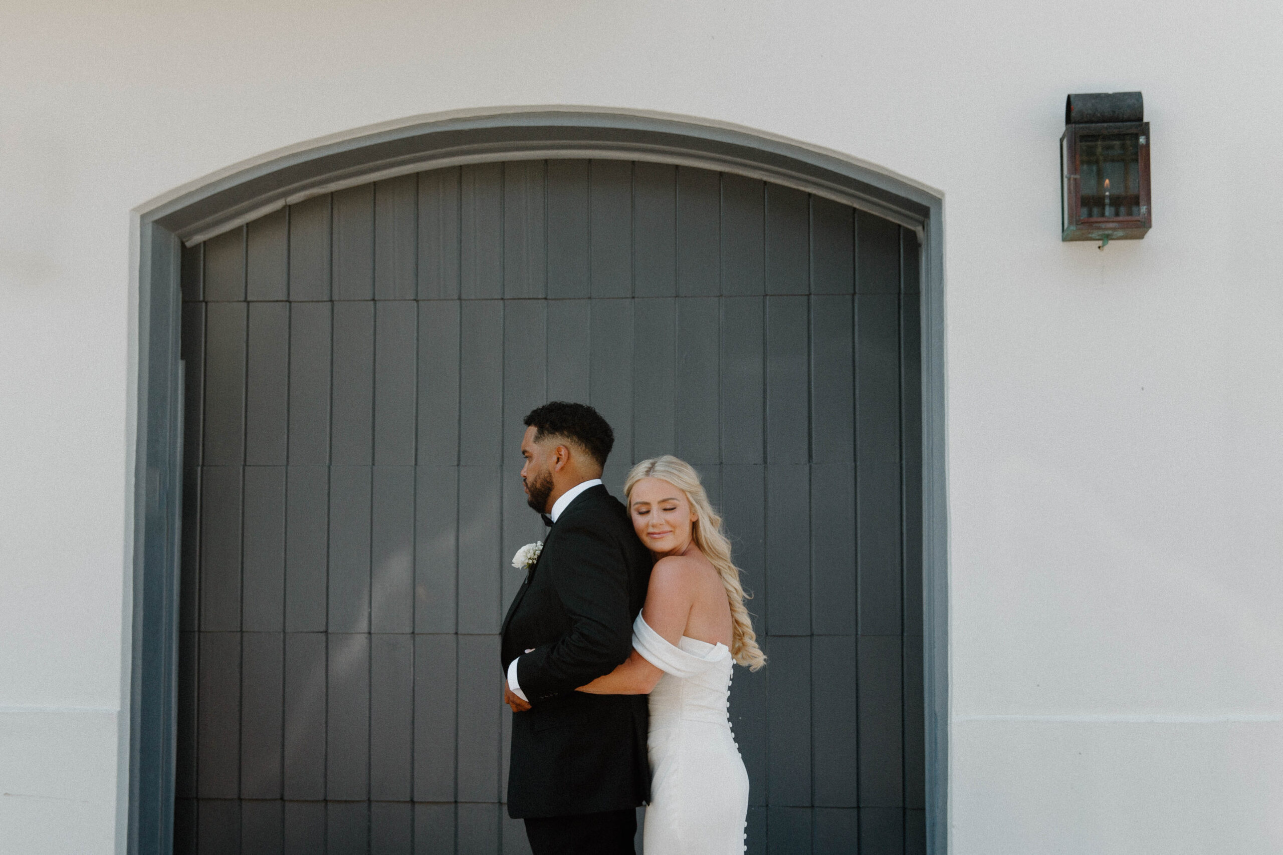 A woman hugging onto her partner from behind during their first look for their rosemary beach destinations wedding in Florida
