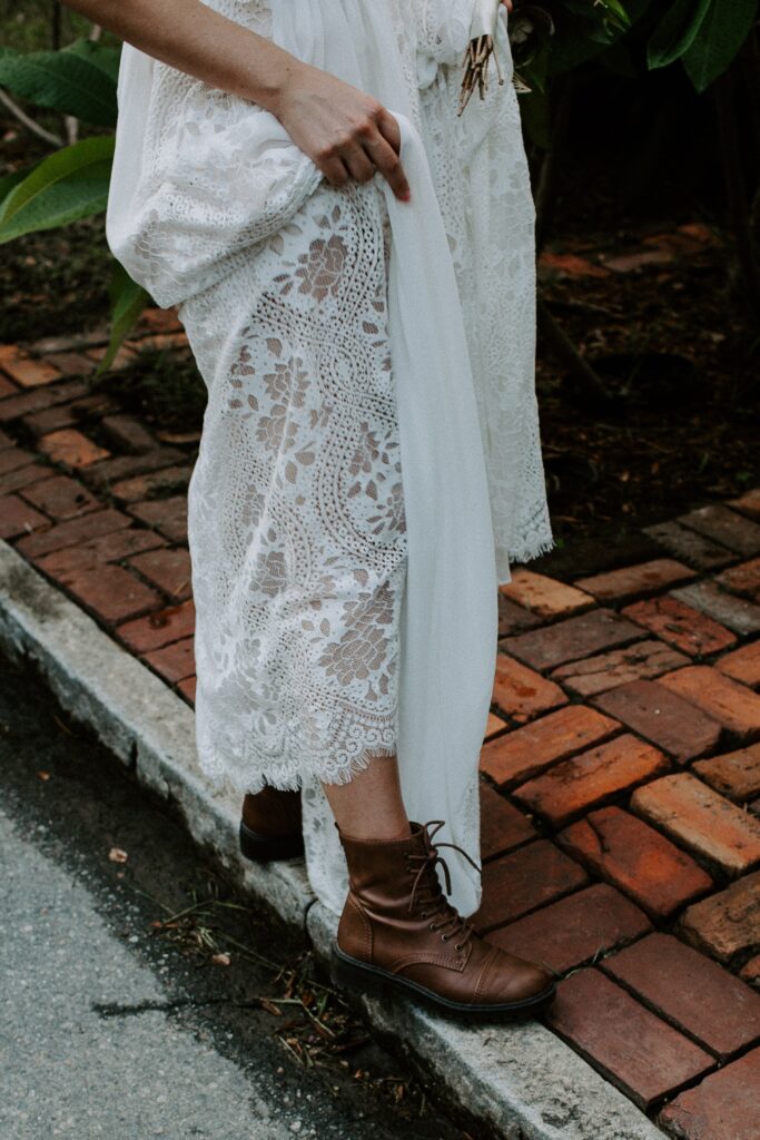A woman holding her dress up to show off her boots used for their elopement in Savannah, Georgia