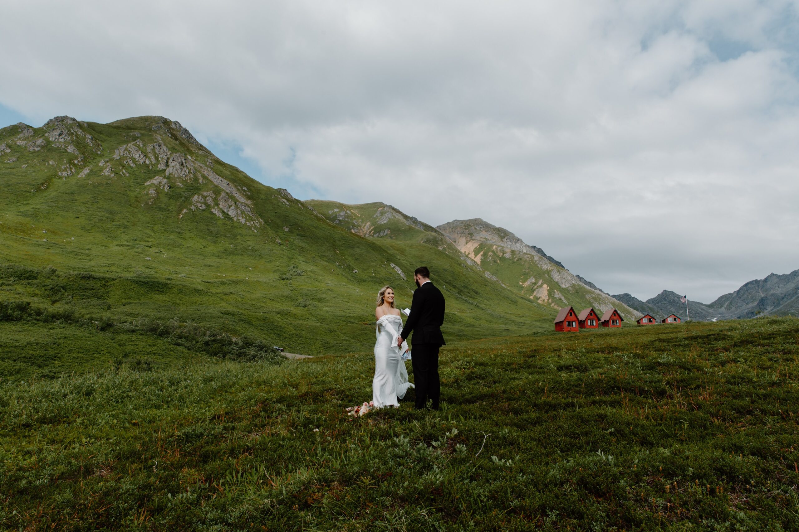 A couple saying vows to each other surrounded by mountains during their alaska elopement