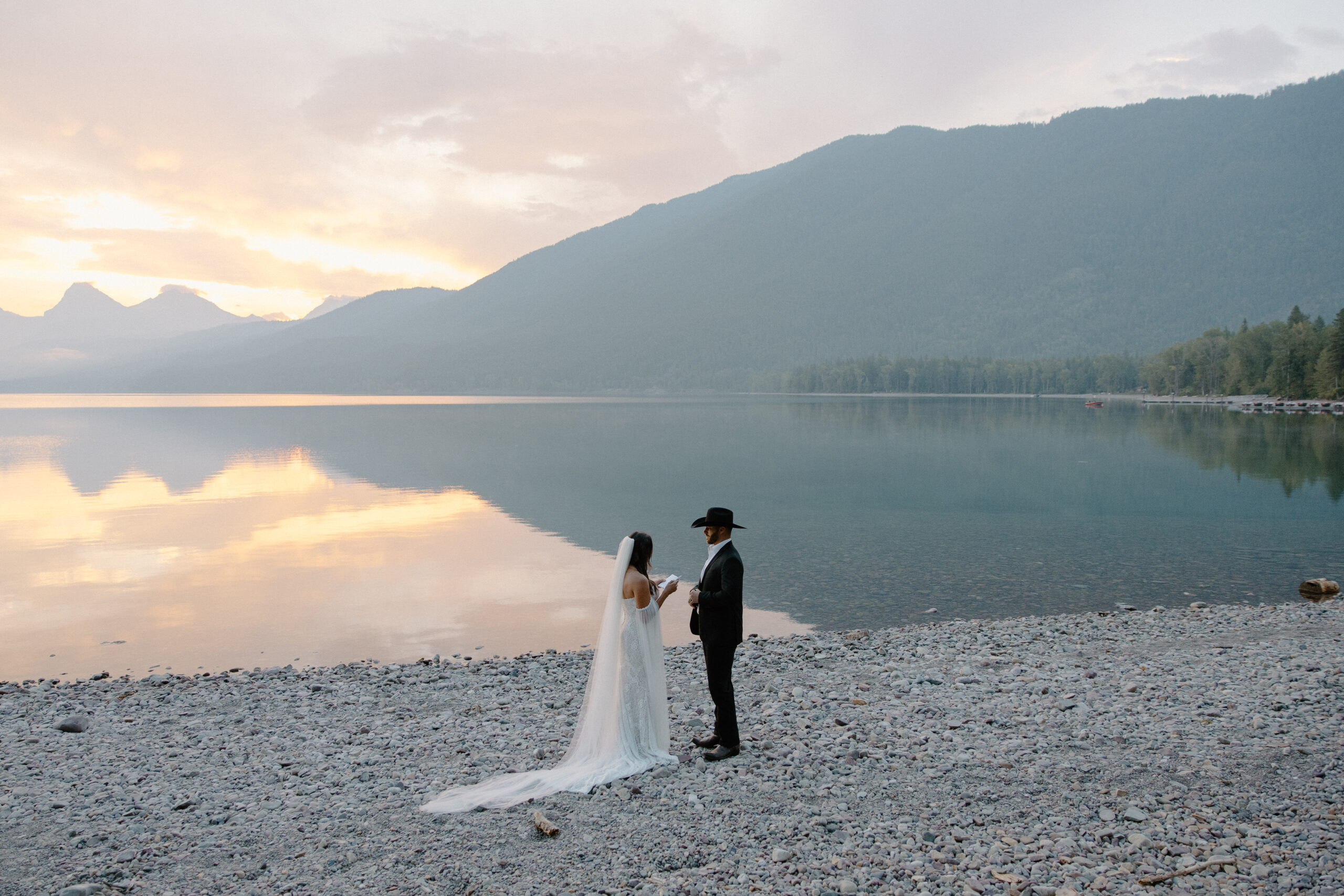 A woman reading vows to her partner who has a cowboy hat on during their western themed Montana elopement