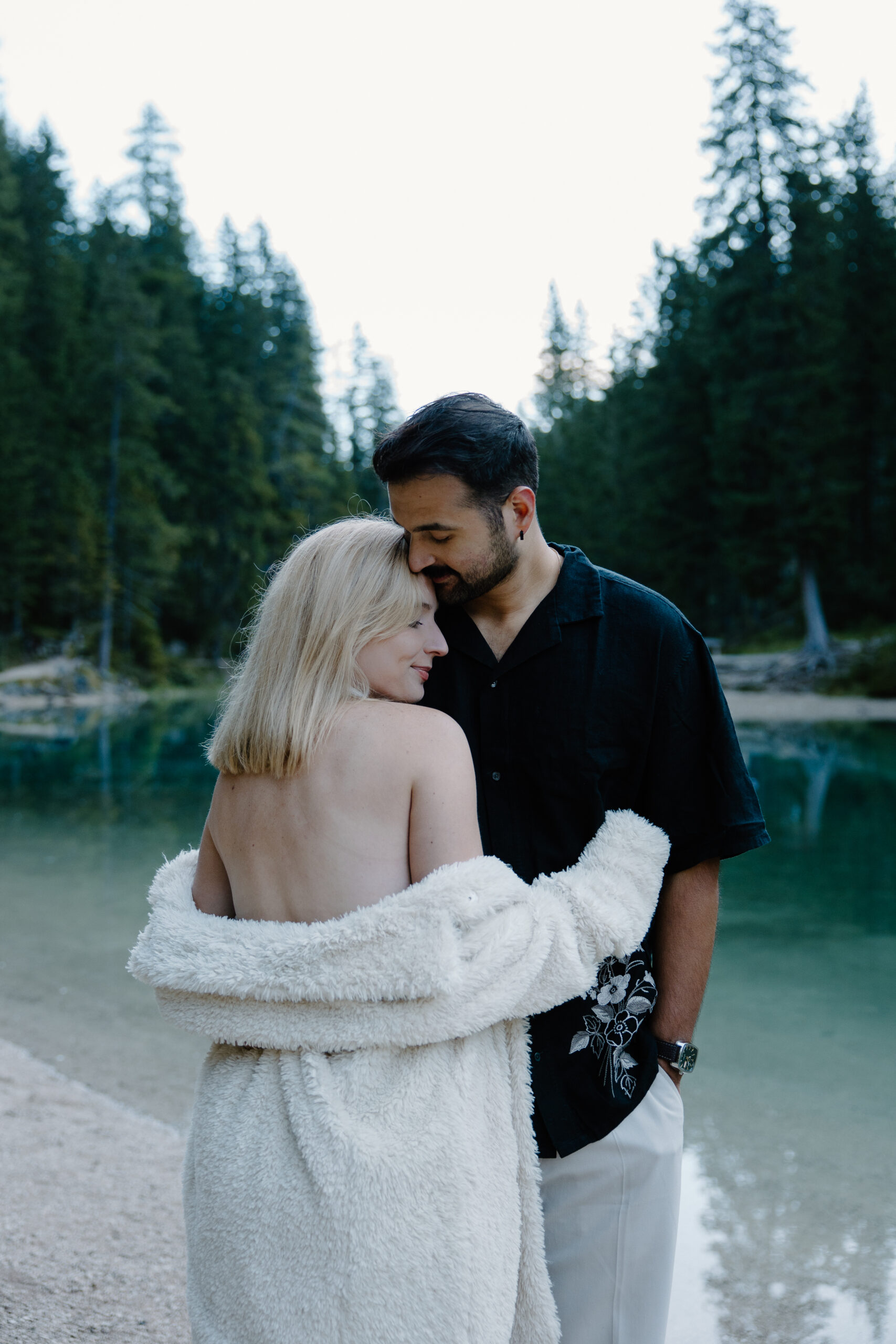 A couple in wedding attire hugging on to each other as the sun rises during their all day elopement in northern italy