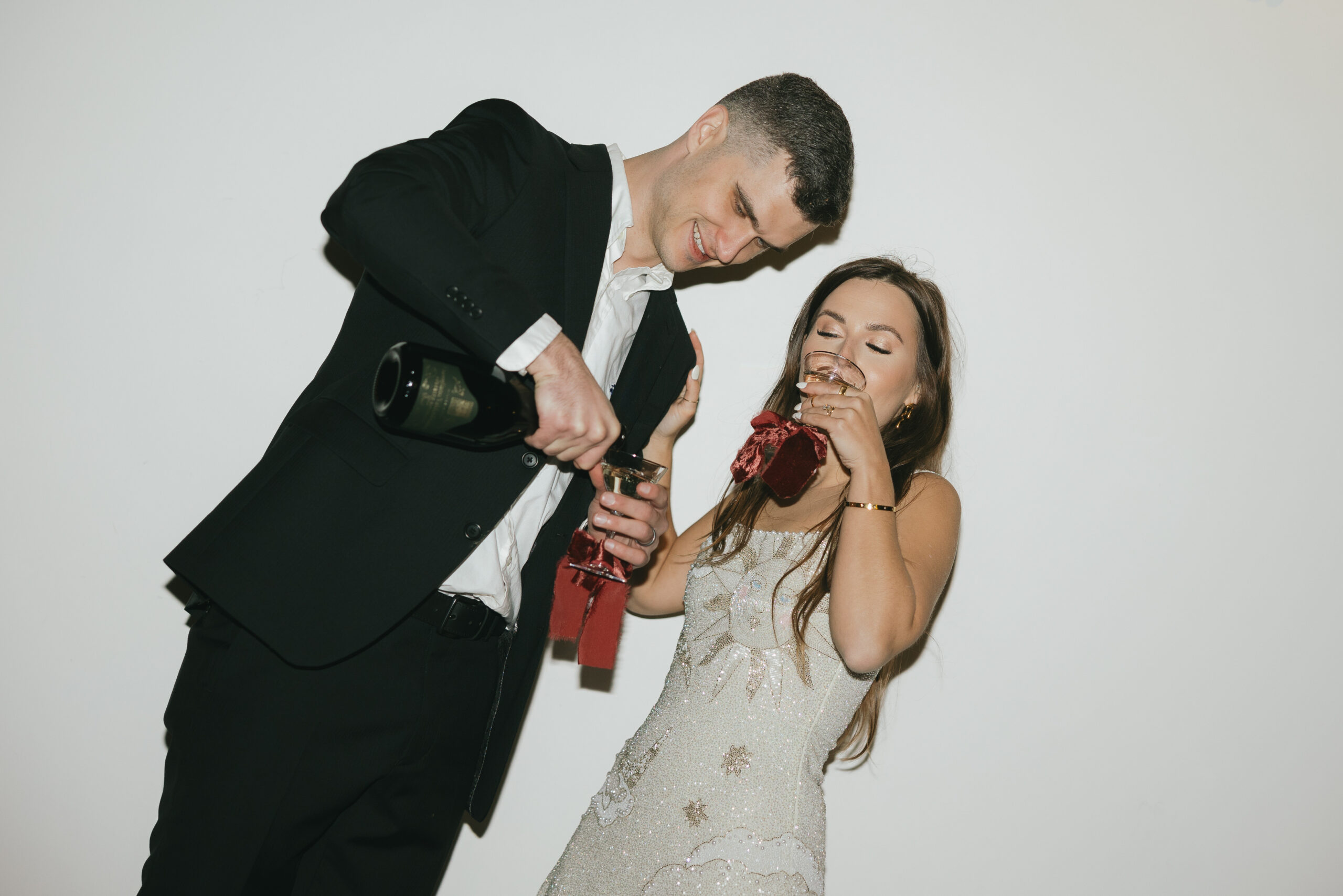 A man pouring champagne into a glass as his new wife takes a sip of hers during their 30-a wedding in Rosemary Beach