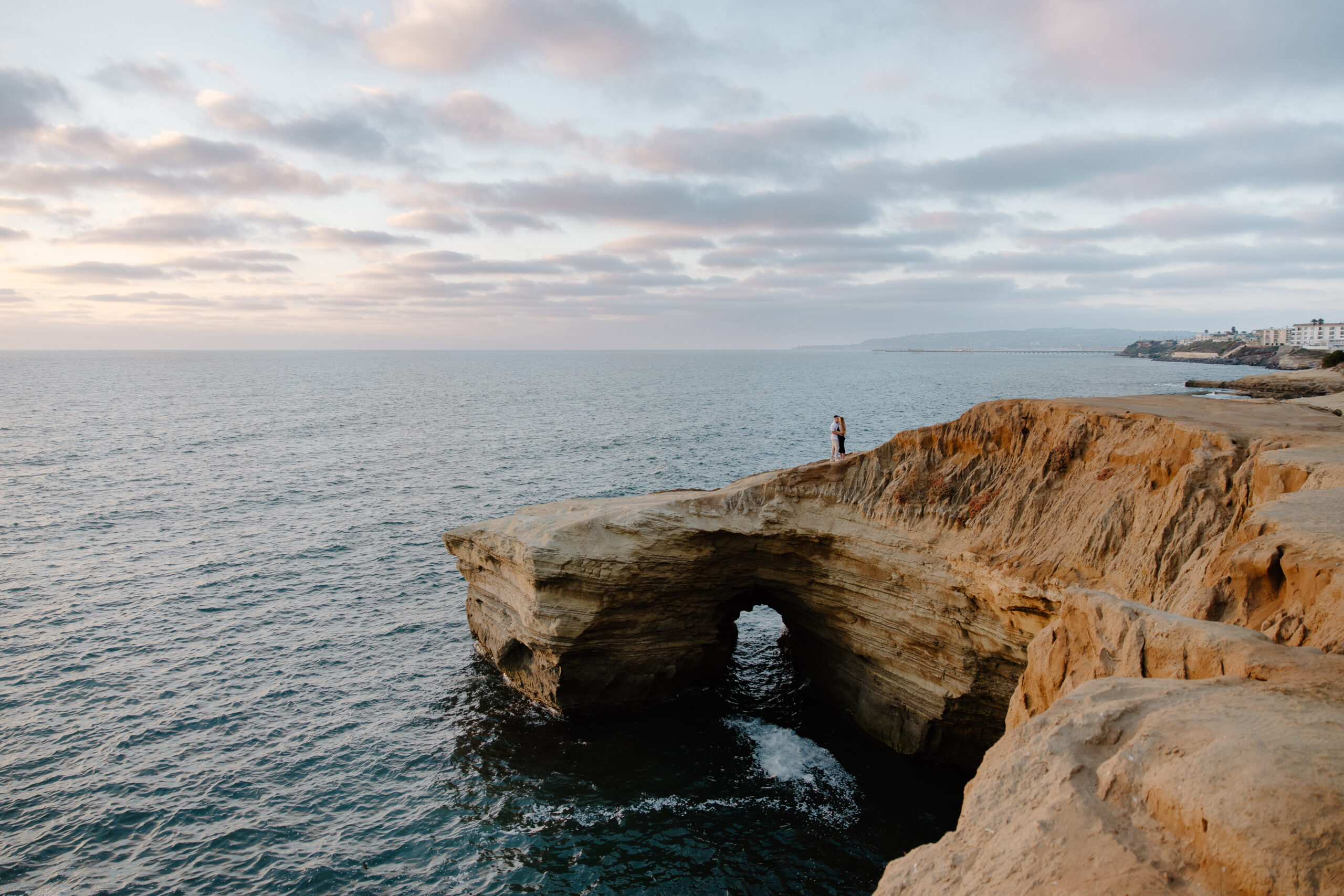 A couple standing together as the sun sets during their California couple session in San Diego