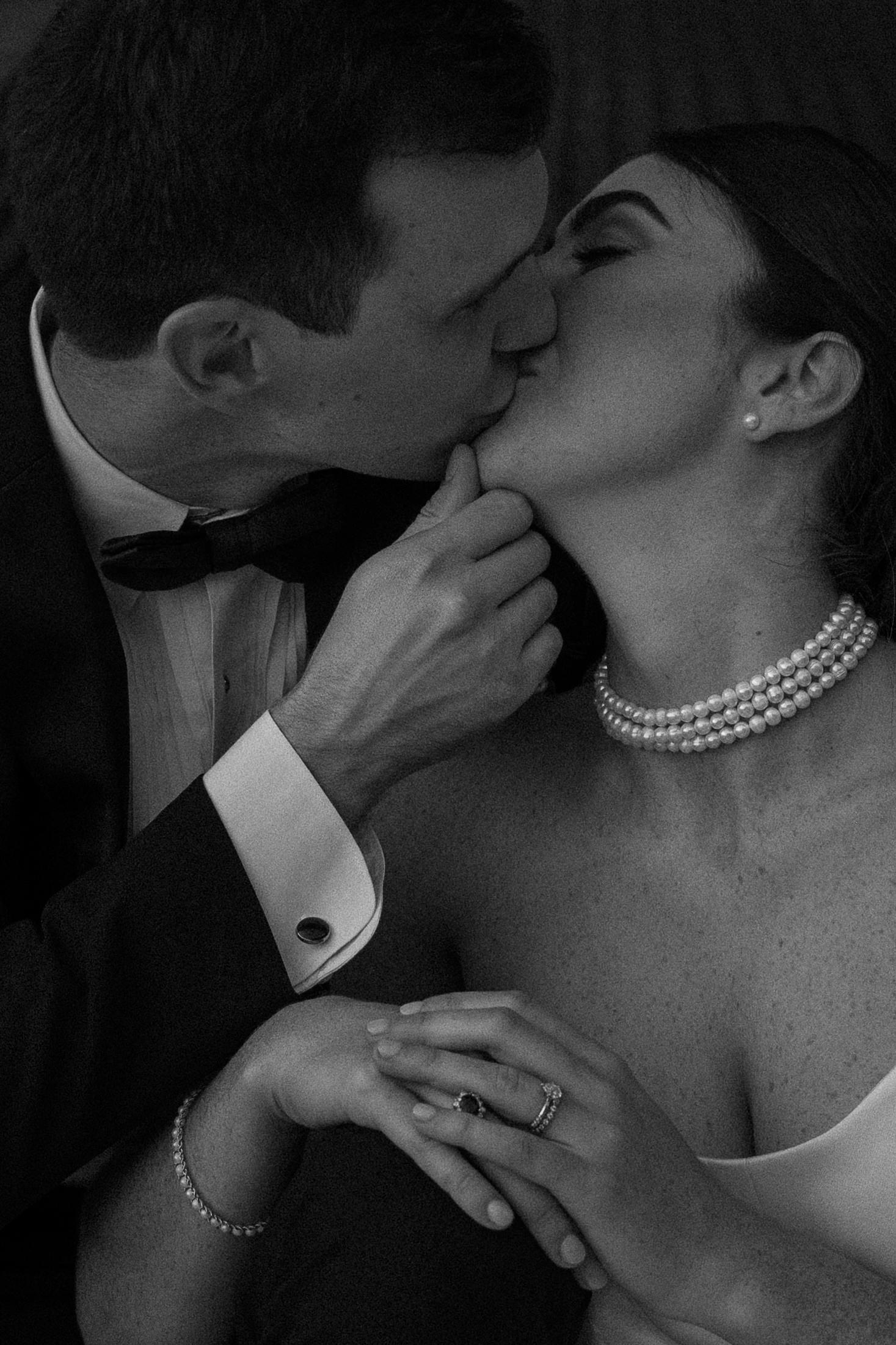 A man giving his partner a kiss as she is leaning on his knee during their massachusetts fall wedding