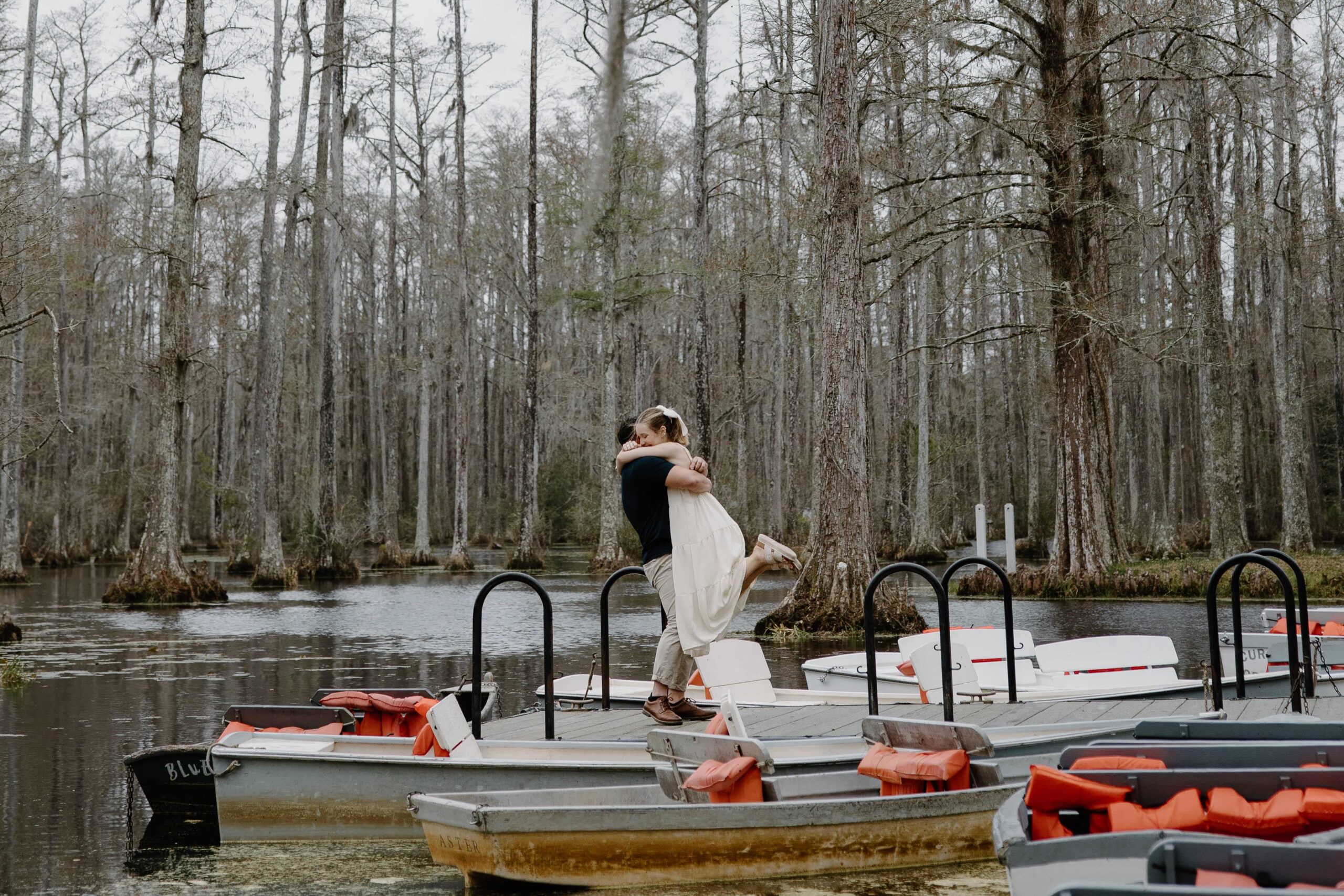 A woman giving her partner a big hug after he proposed in Cypress Gardens