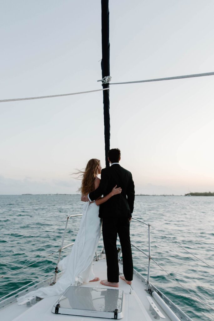 A woman with her arms wrapped around her partner as they both look off at the sunrise during their Key west, Florida elopement