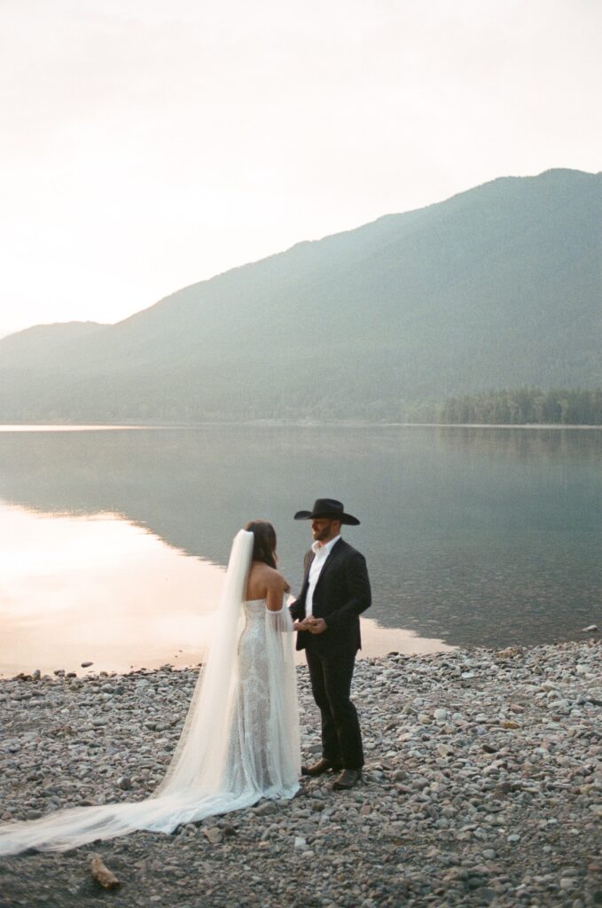Couple seeing each other for the first time in their wedding attire at Lake McDonald during their sunrise elopement in Glacier National Park