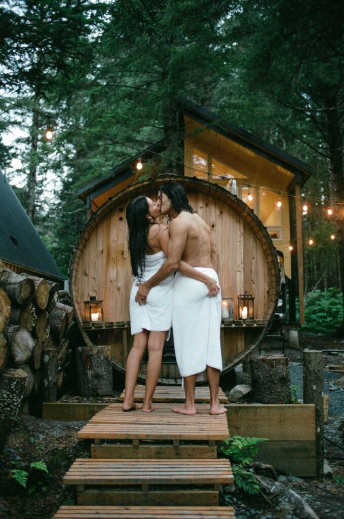 A couple sharing a kiss in front of a sauna during their Alaskan elopement