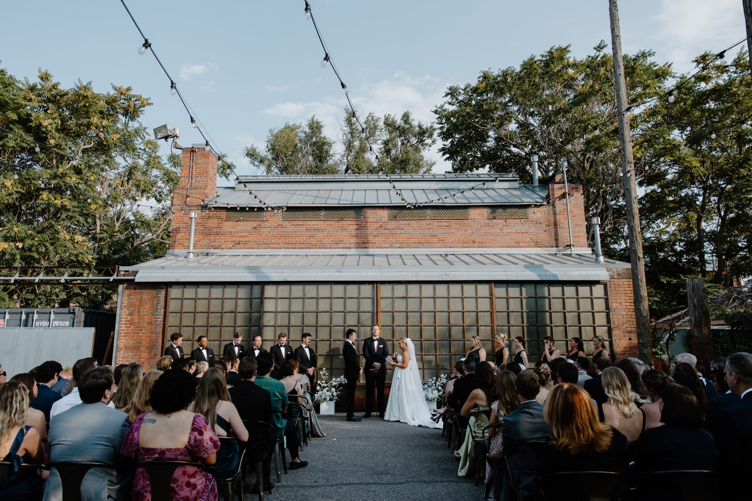 Guests seated for an intimate courtyard ceremony under string lights at Blanc Denver.