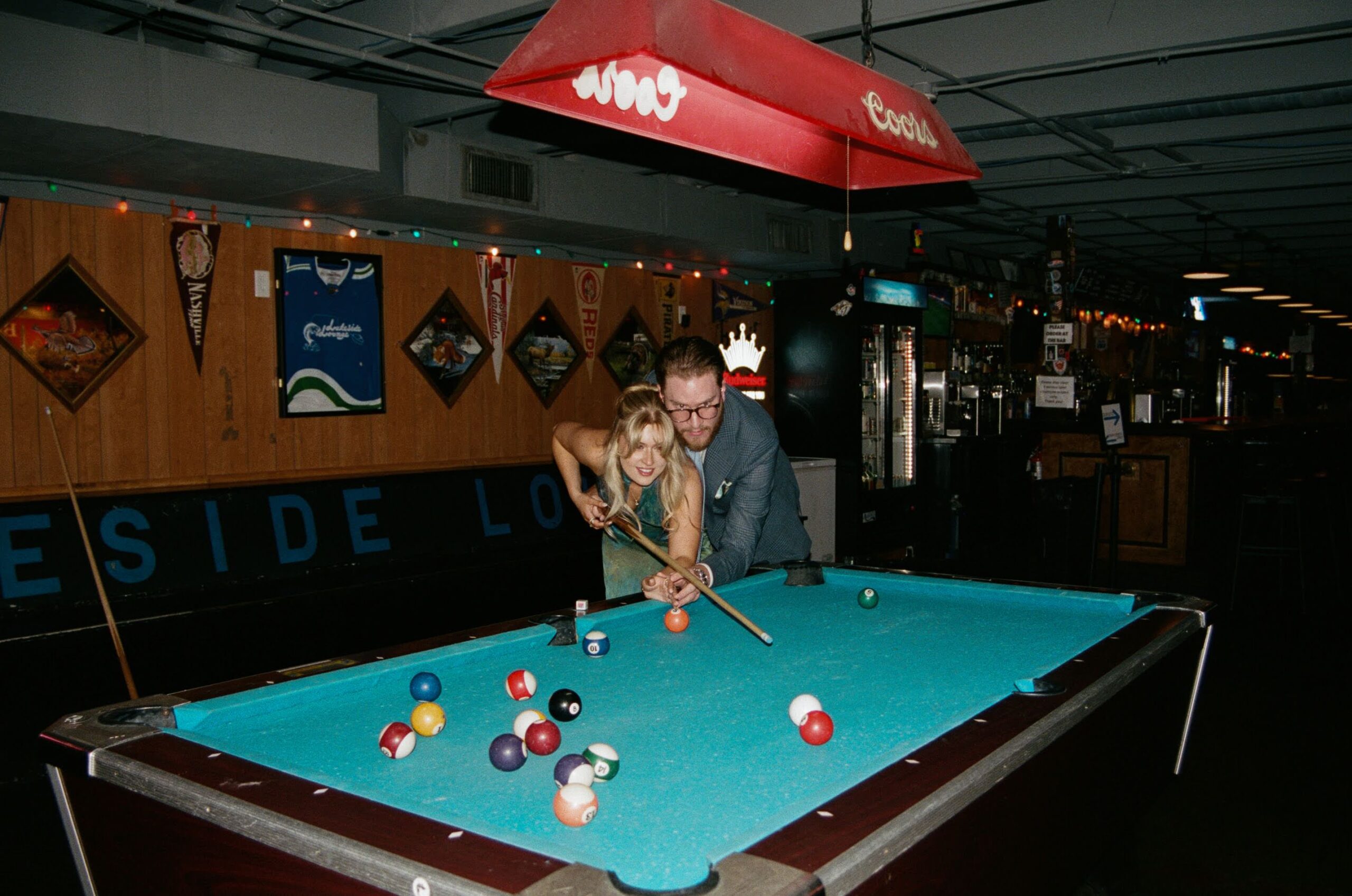 Couple playing a game of pool inside Lakeside Lounge in the morning.