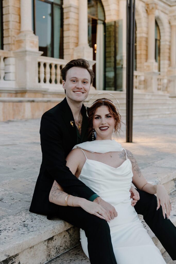 Matt and Elle sitting together and smiling together in Hvar old town during their elopement.
