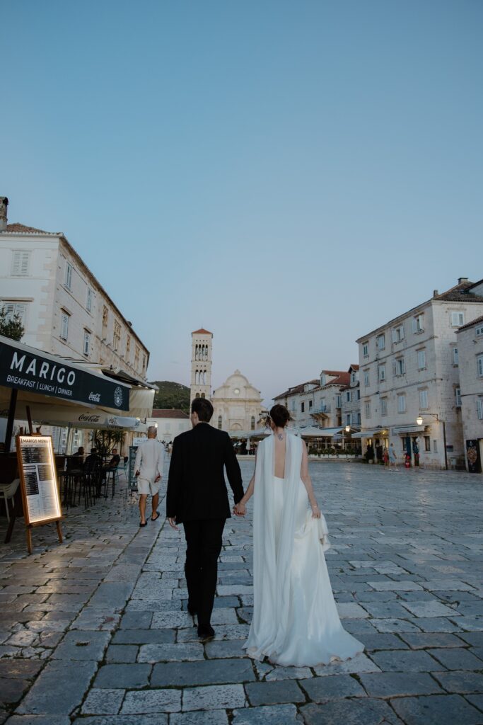 Matt and Elle walking hand-in-hand through Hvar’s old town cobblestone streets.