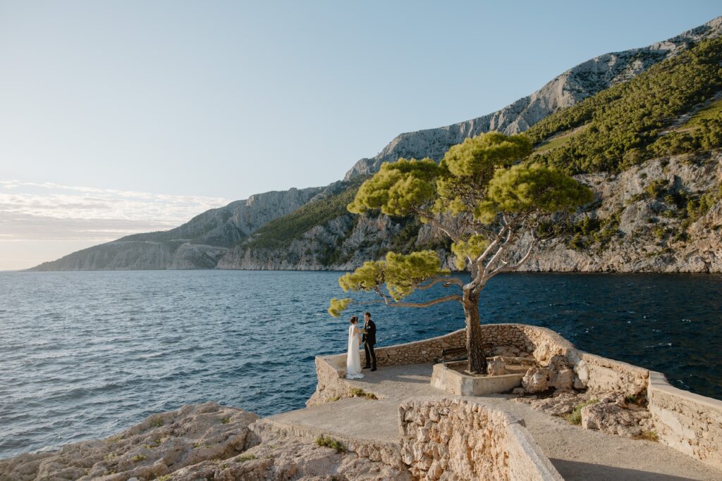 Romantic Adriatic coastline view with Matt and Elle on a cliff saying their vows during their elopement.
