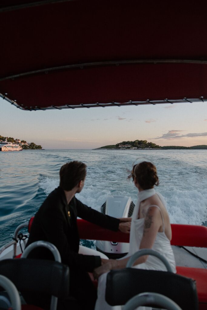 Matt and Elle on a boat in Hvar, Croatia at sunset during their elopement adventure.