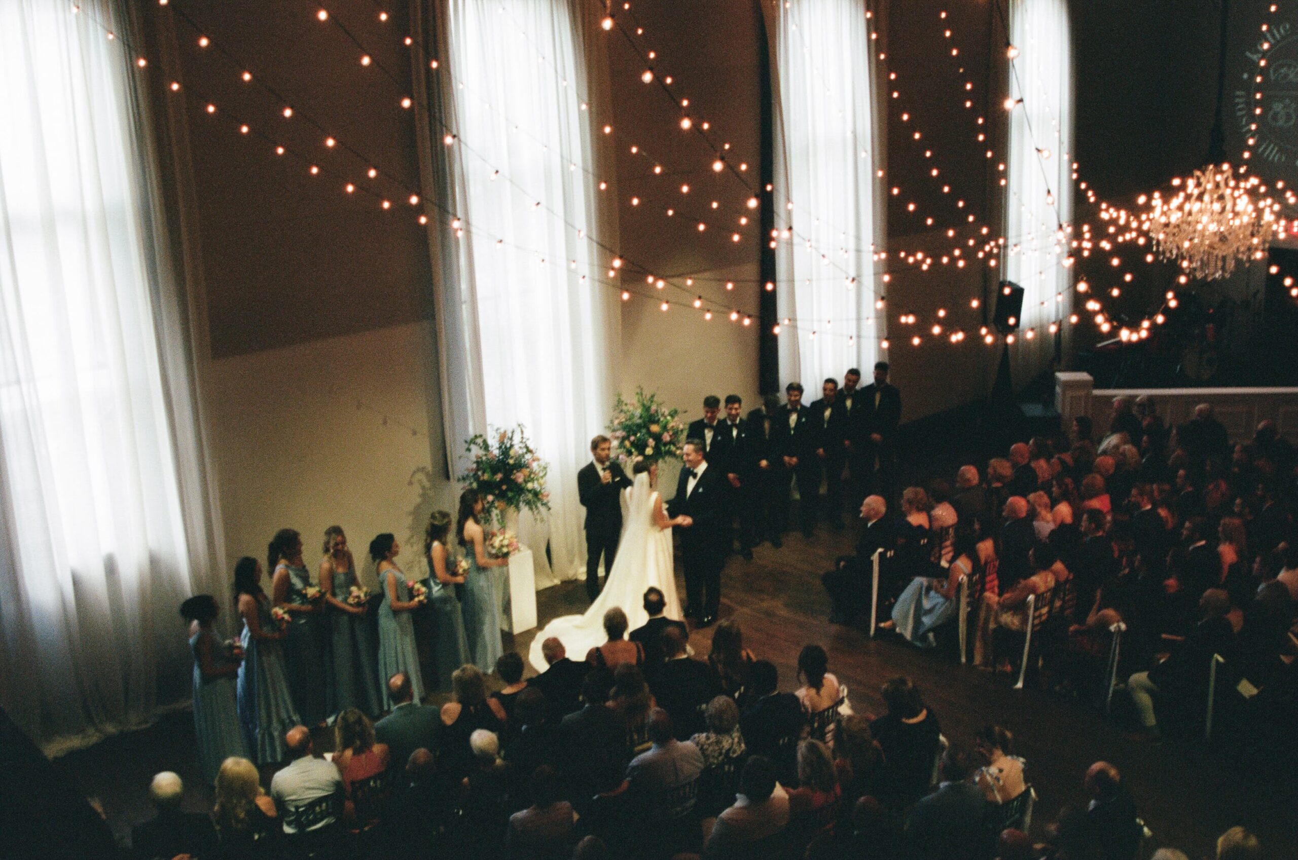Wedding ceremony inside the Bell Tower with string lights and guests seated
