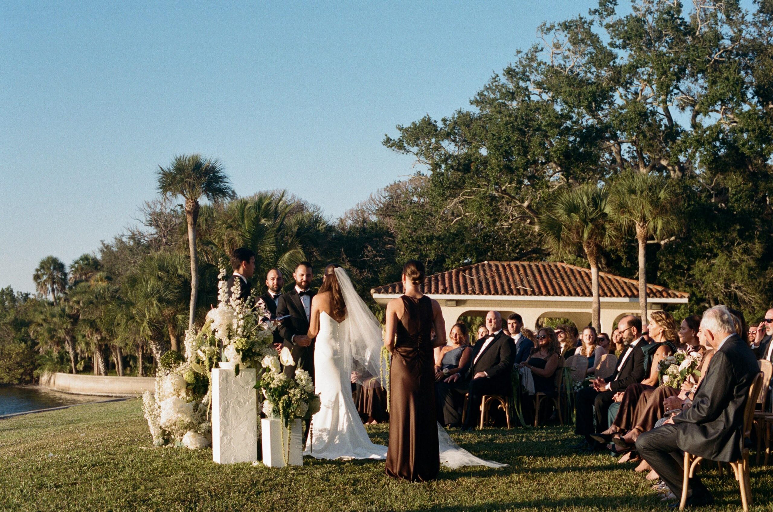 Wedding ceremony with guests seated facing the water during a fall wedding in Florida