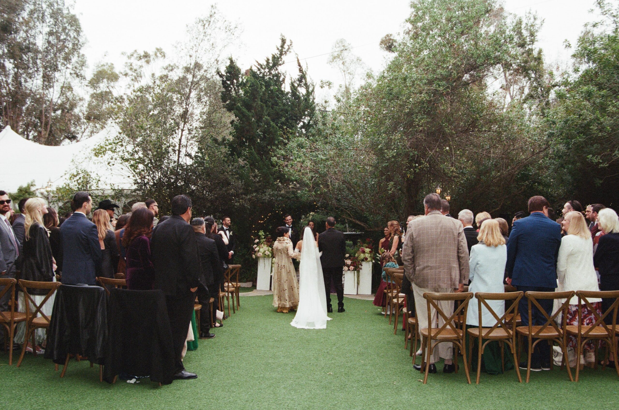 Outdoor garden wedding ceremony with guests seated beneath trees in San Diego, California