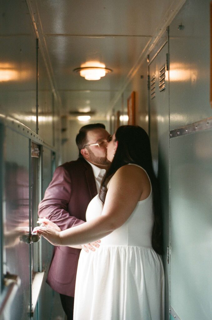 Engaged couple kissing inside the Sky Railway train during their Santa Fe New Mexico engagement photos on film